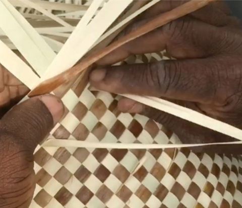 Hands weaving natural fibers